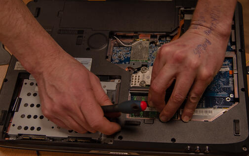 Vrijwilliger-reparateur van Repair Café Gent neemt laptops onder handen