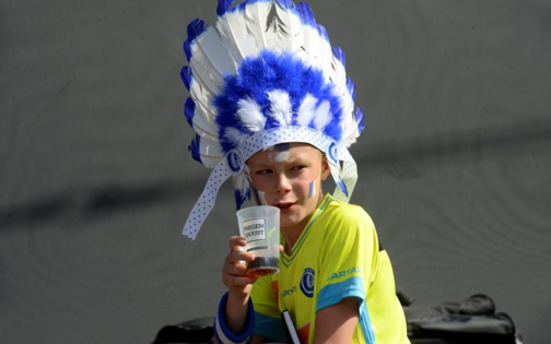Kind met blauwwitte pluimen op hoofd en herbruikbare beker Gent