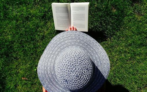 Bovenaanzicht lezende vrouw met hoed