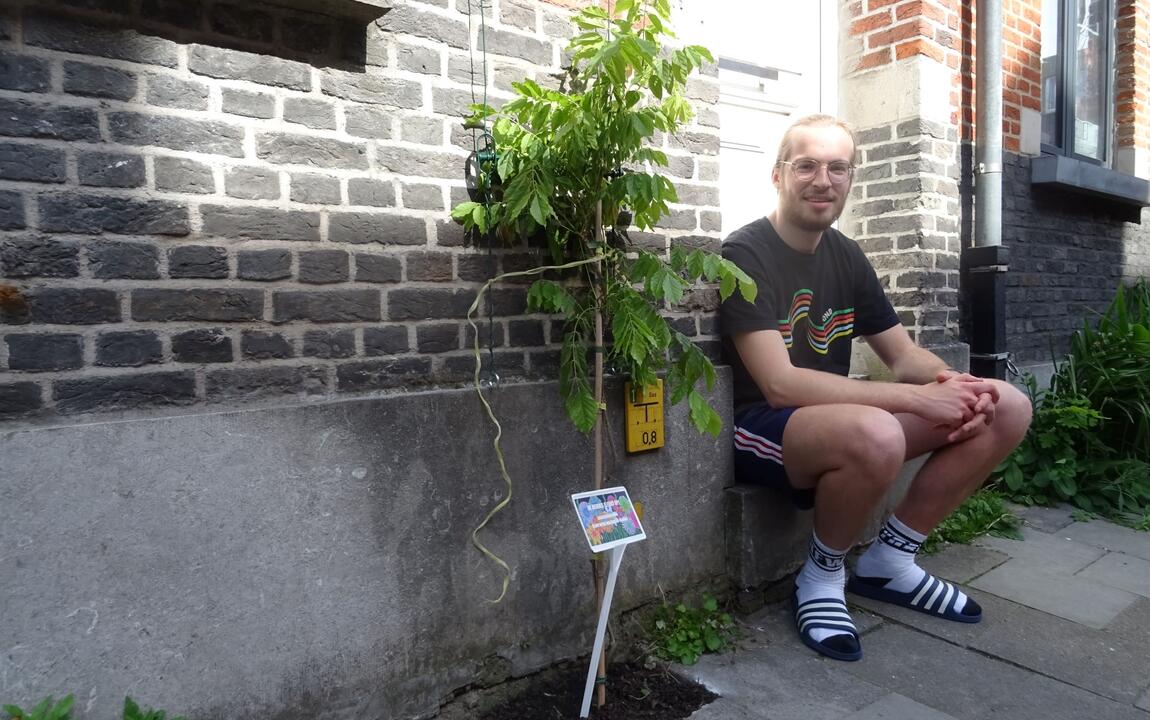 Student poseert naast nieuwe geveltuin met klimplant in Gent