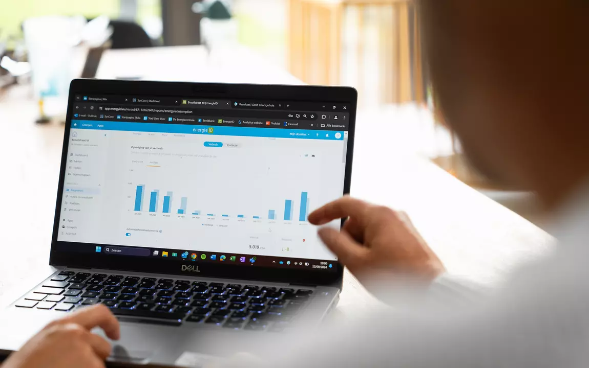Personen kijken op een laptop naar een grafiek over energieverbruik