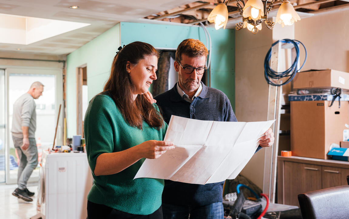 man samen met adviseur bij bouwplannen