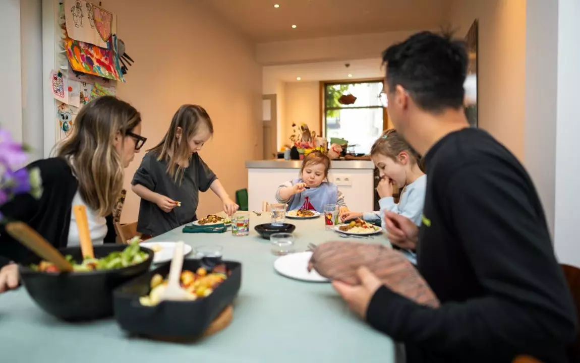 Gezin met kinderen eet aan tafel