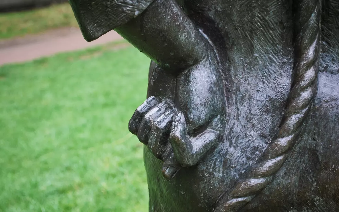 Het beeld van de stroppendrager houdt stiekem zijn duim tussen zijn wijs- en middelvinger