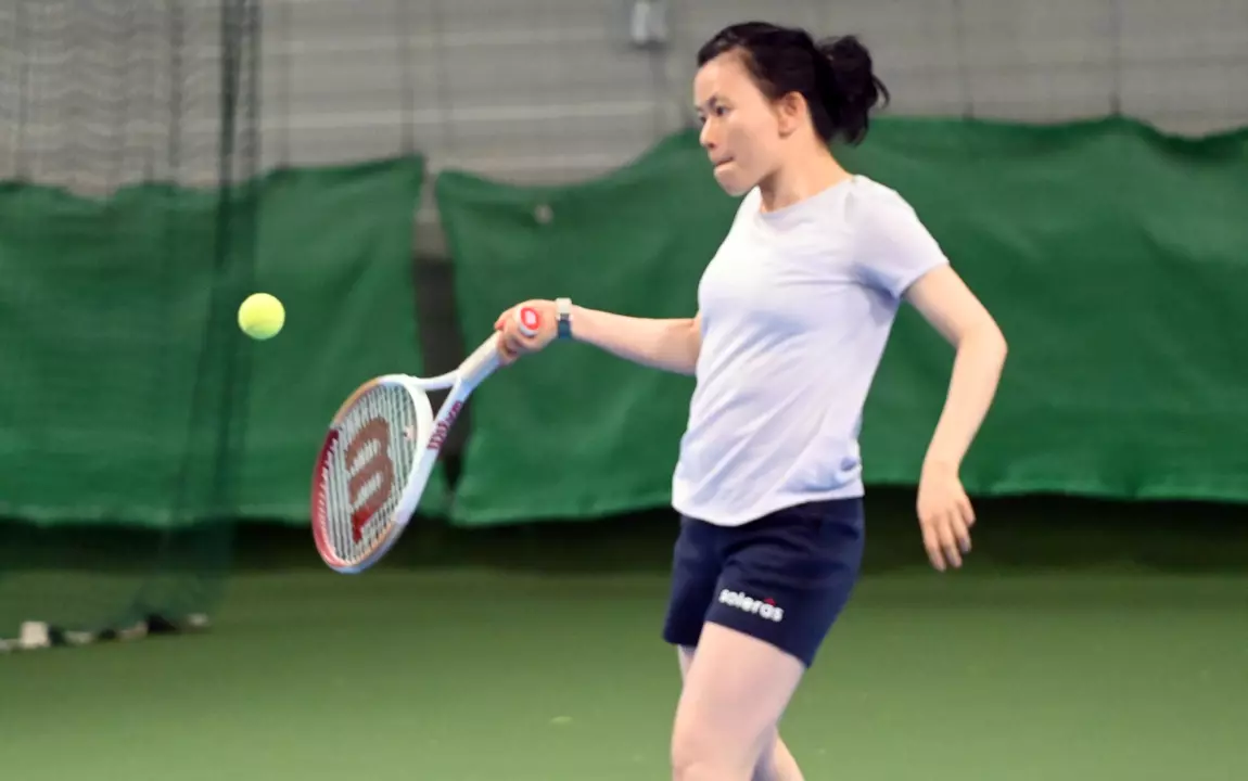 een vrouw die leert tennissen tijdens de tenniscursussen van de sportdienst