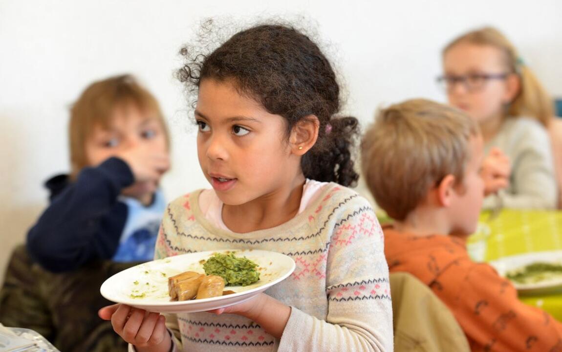 Schoolmaaltijden meisje met bord stoemp en worst