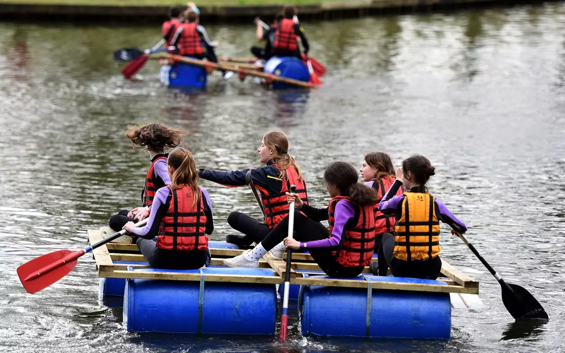 Kinderen die op een zelfgemaakt vlot varen op de vijver van de Blaarmeersen