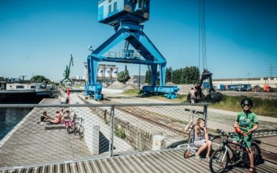 Blauwe kraan aan de Oude Dokken waarbij fietsers rijden op de aangelegde Schipperskaai