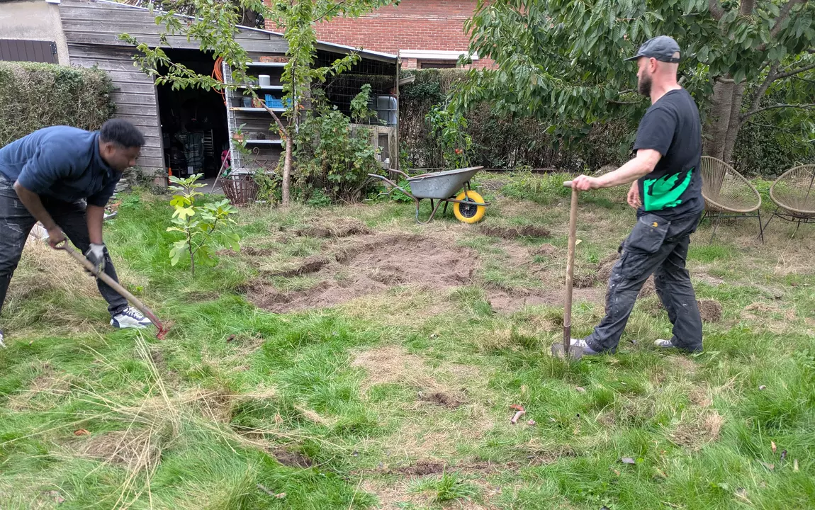 Twee mannen graven een wadi in de tuin van een Gentse woning