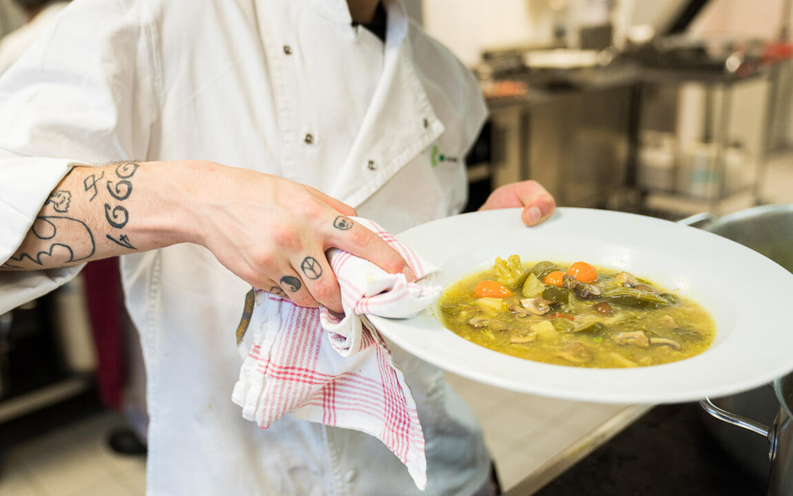 Restaurantmedewerker presenteert een bord met een bereide maaltijd