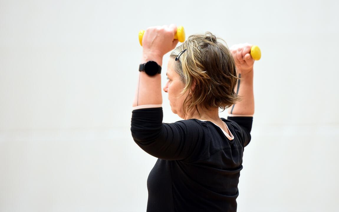 een vrouw die sport met halters