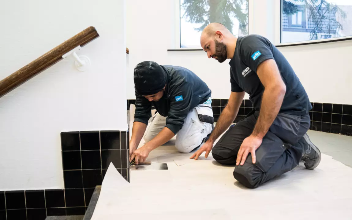 twee mannen die een vloer leggen