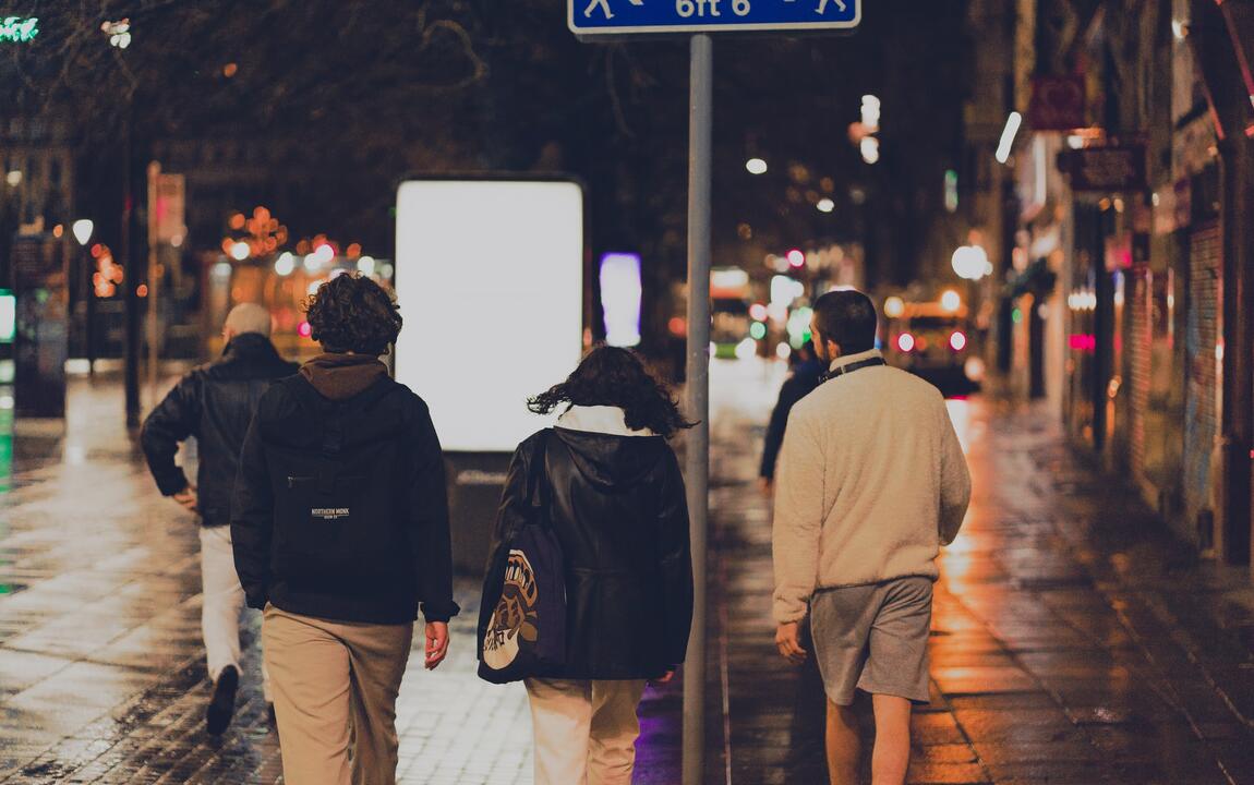 Drie jongeren lopen 's avonds in een stad