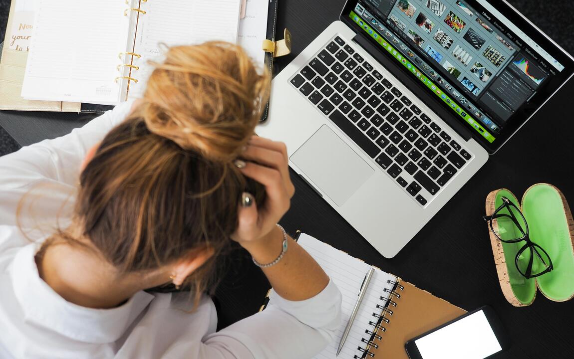 hand in de haren aan de laptop