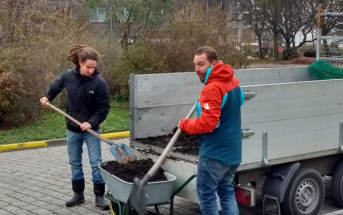 Bewoners planten fruitbomen.