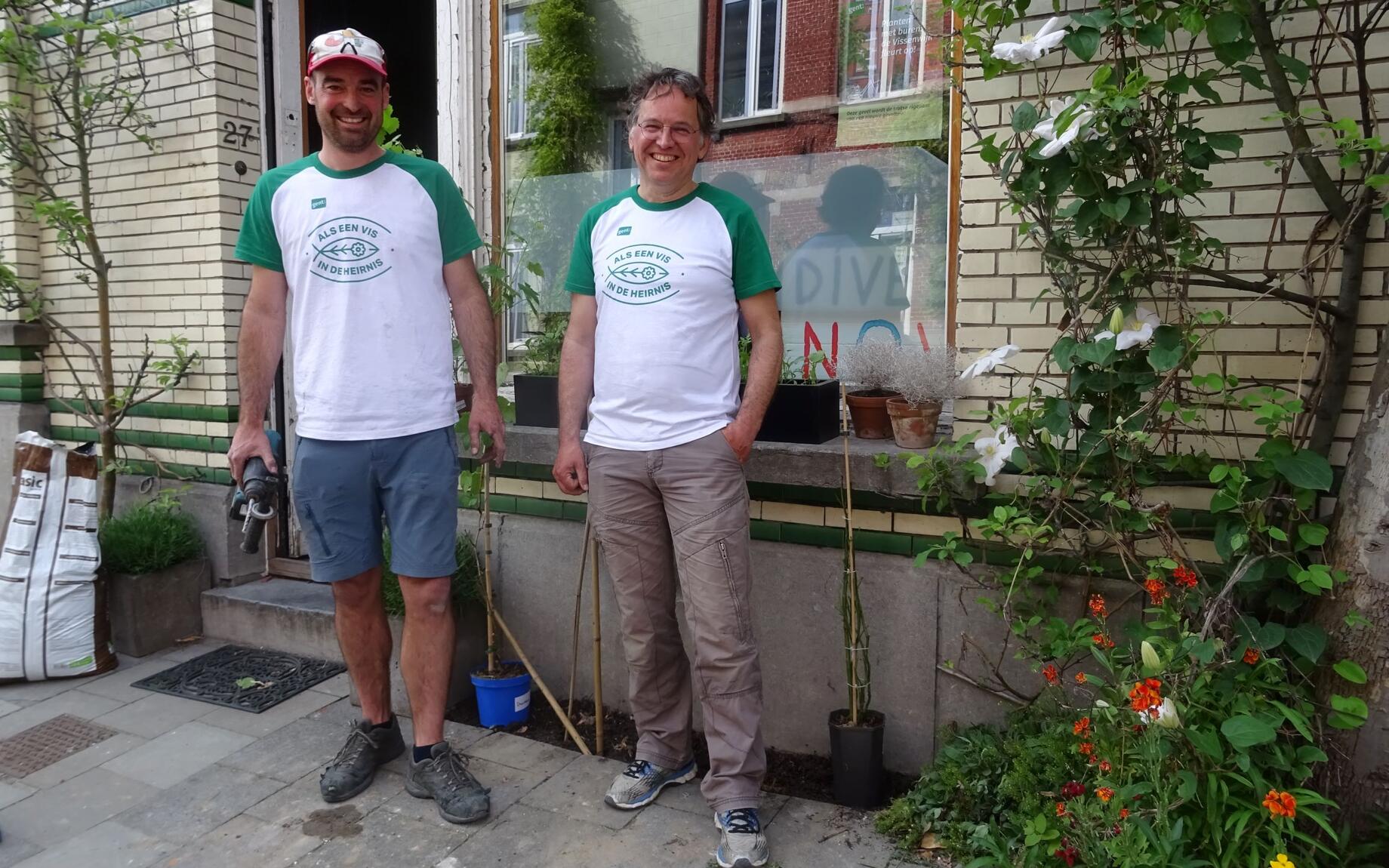 Twee mannen van het Gents MilieuFront en de Geveltuinbrigade poseren bij een geveltuin in de Heirniswijk