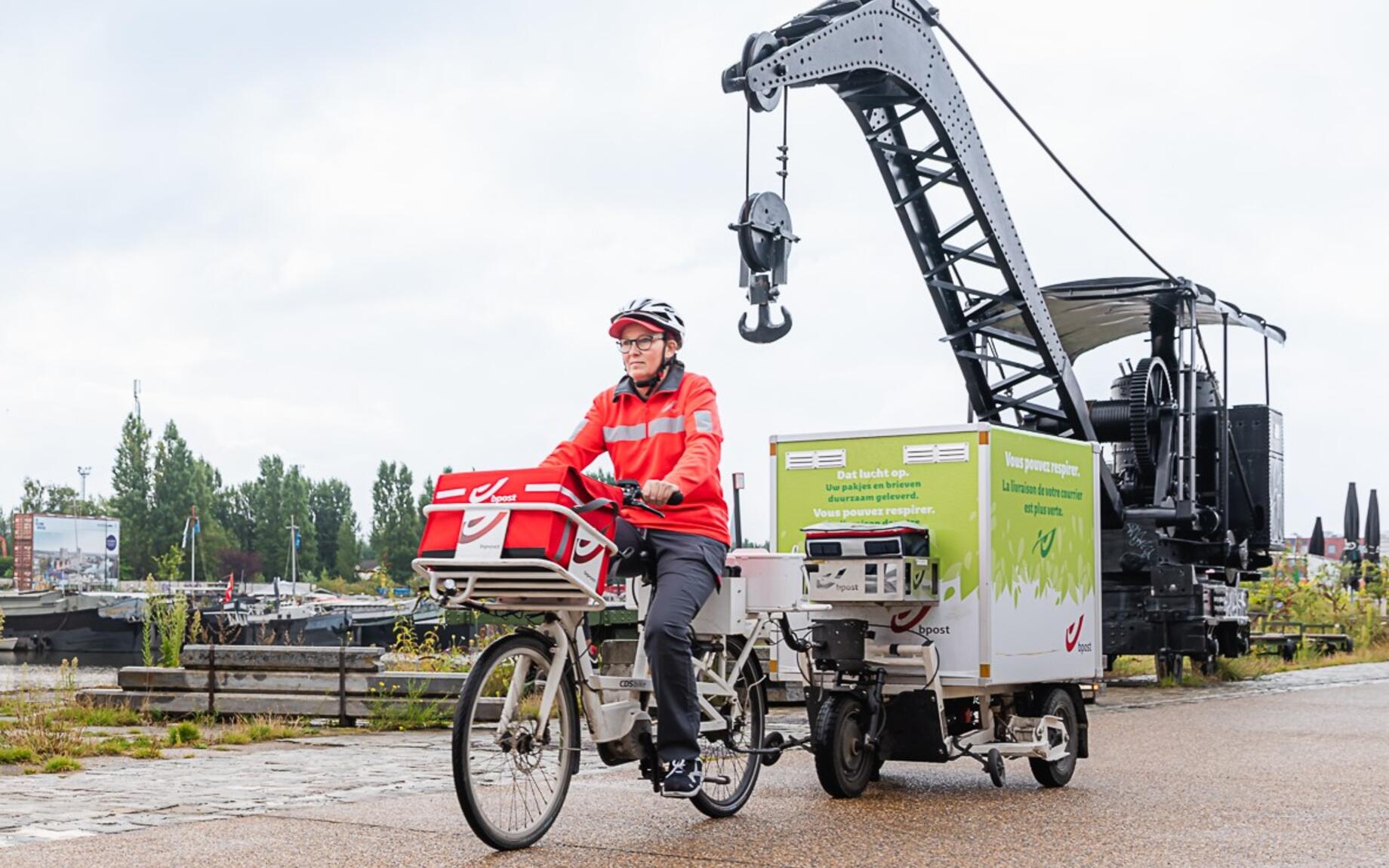 Een postbode met fietstrailer onderweg in Gent