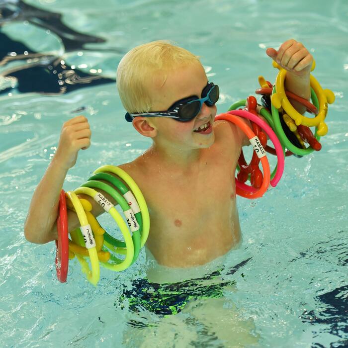 Kindje in het zwembad dat stoer poseert met ringen om de armen
