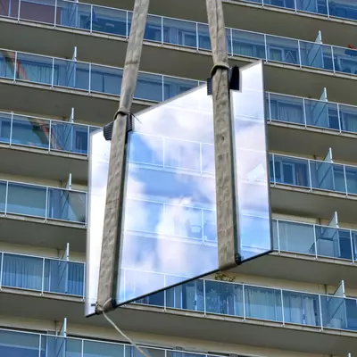 Een raam wordt naar boven gehesen voor de renovatie van een appartement in Gent