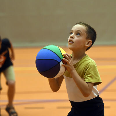 Jongetje klaar staat om te mikken naar het basketdoel