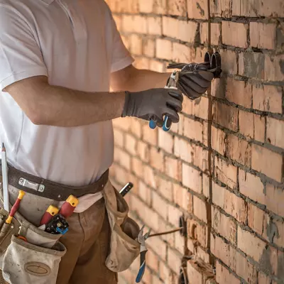 Man werkt aan kabels in een huis dat gerenoveerd wordt