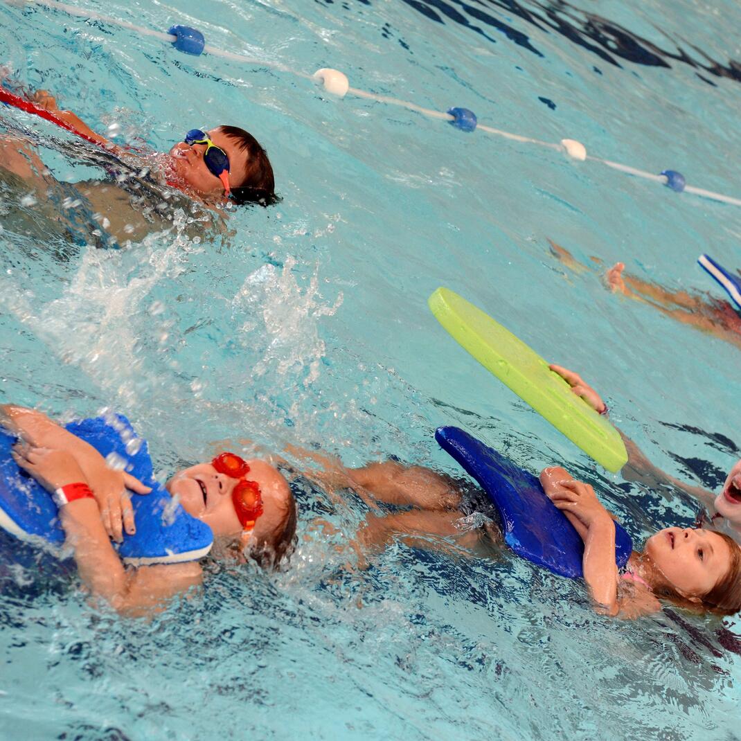 Kindjes die op de rug zwemmen met een plankje