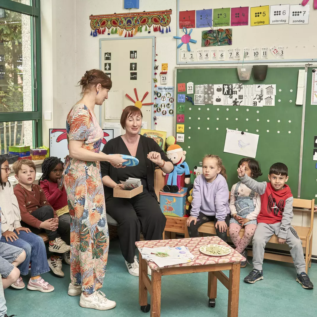 Leerkrachten geven les aan kleuters