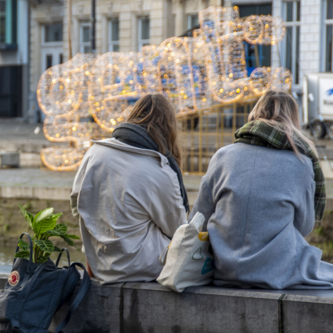 twee personen zitten aan de Graslei