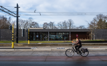 een vrouw fietst voorbij de tramhalte in Zwijnaarde