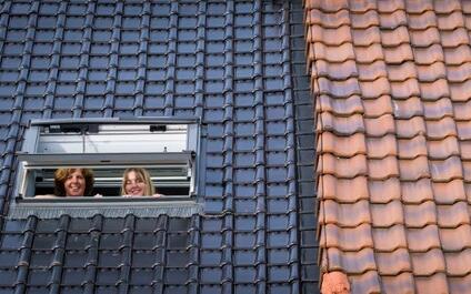 Annelies & Lara kijken door de open Velux van hun geïsoleerde dak