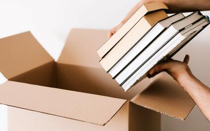 Boeken in een kartonnen doos leggen
