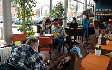 studenten spelen muziek in cafetaria woonzorgcentrum
