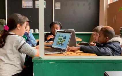 Kinderen aan het werk op de laptop in het Digipunt
