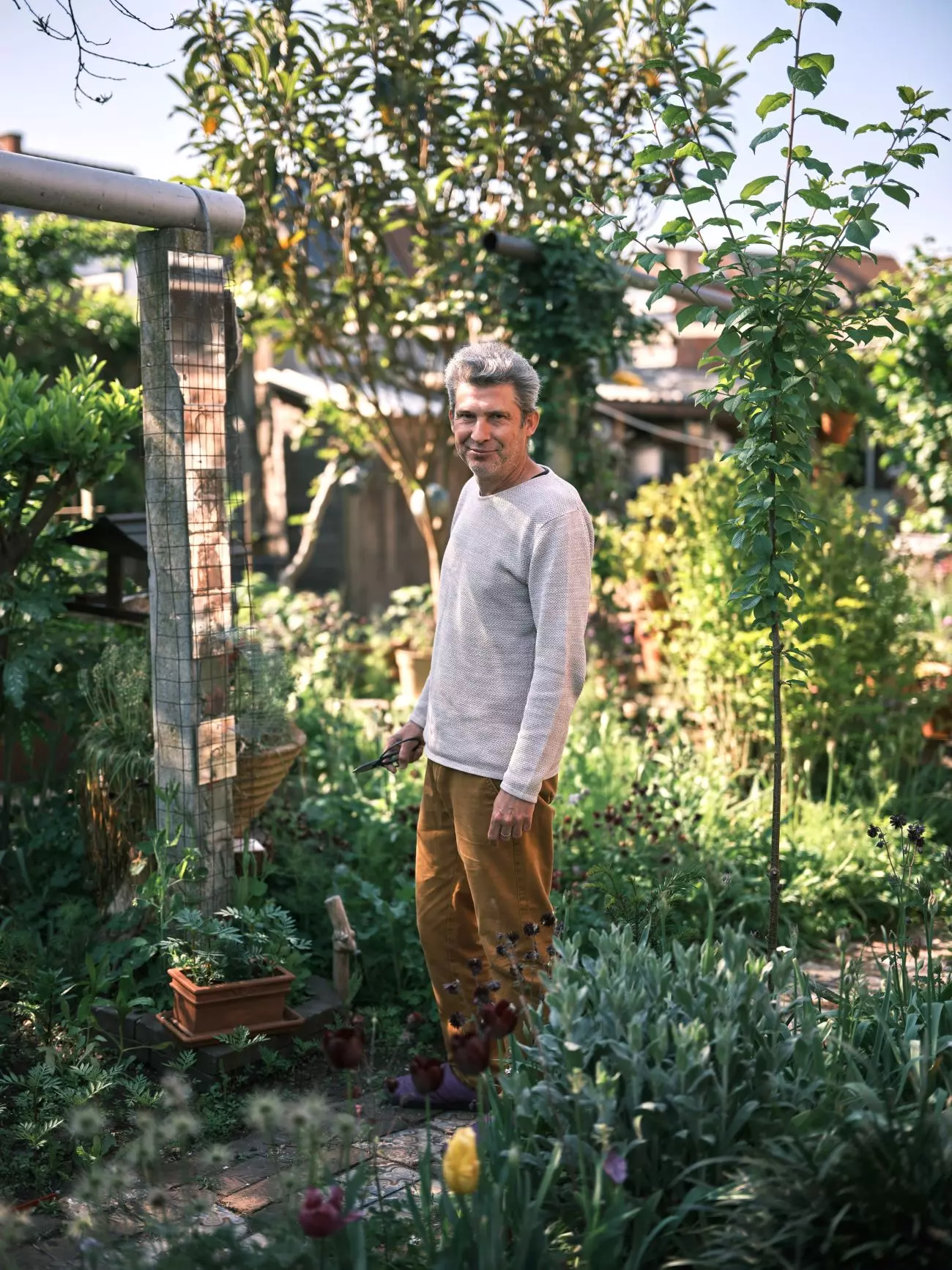 Man in begroeide stadstuin
